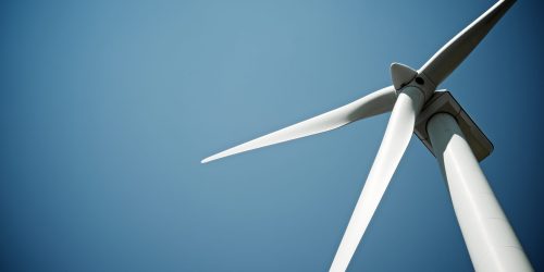 Wind turbine against clear blue sky, showcasing renewable energy technology and sustainable power generation.